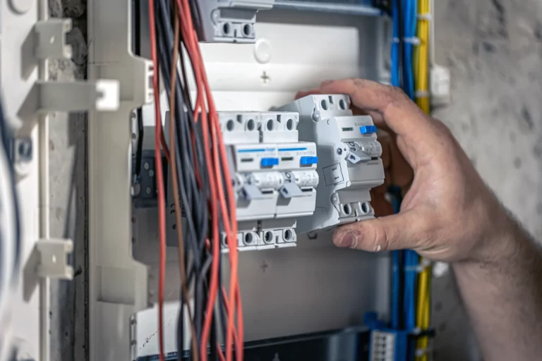 electrician installs machines in an electrical panel