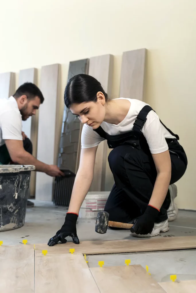 girl in black overalls laying tiles on the floor